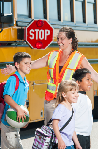 students crossing street with crossing guard
